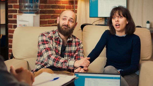 Couple solving marriage problems at counseling session with specialist