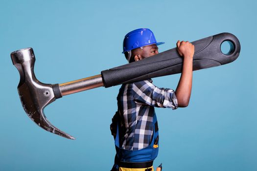African american builder walking with giant hammer