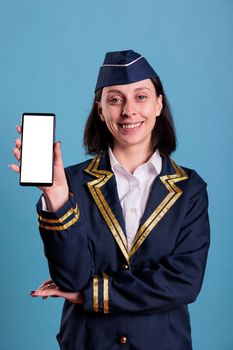 Smiling flight attendant showing smartphone with blank white screen