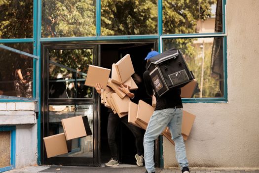 Deliveryman dropping pizza boxes pile at custome