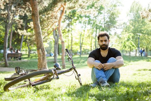 Bearded man sitting next to his bike