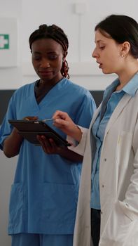 African american physician nurse checking disease expertise on tablet
