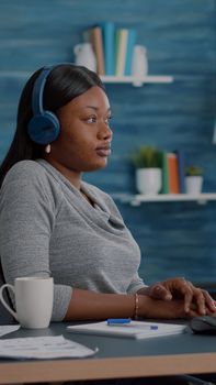 Student with black skin having headphone puts listening online univeristy course