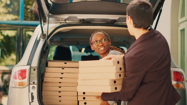 Woman pizzeria courier delivering big fastfood order