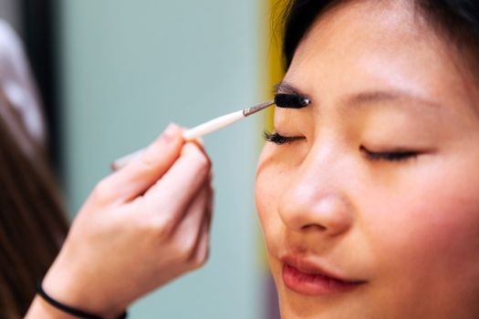 makeup artist combing and making up the eyebrows