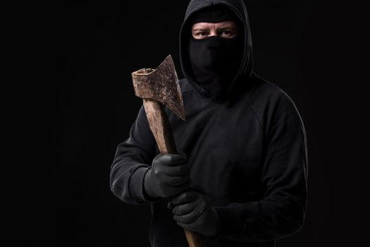Bandit in black mask with hatchet on black background