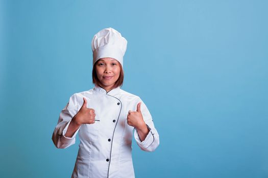 Friendly positive cook doing thumbs up gesture approving gastronomy recipe