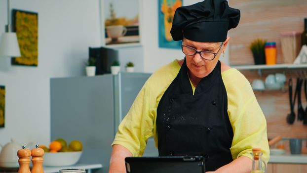 Woman chef using tablet in kitchen