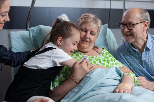 Child hugging grandmother, saying goodbye before finishing hospital visit