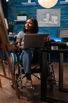 Wheelchair user using laptop to take drawing classes