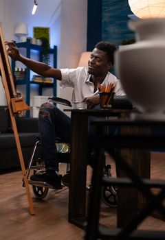 Artist living with disability making vase drawing on canvas