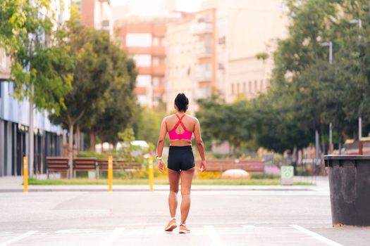 rear view of a female athlete walking on the city