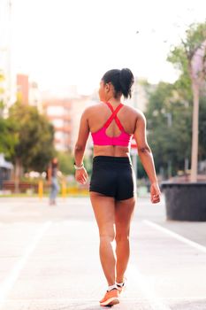 rear view of a female athlete walking on the city