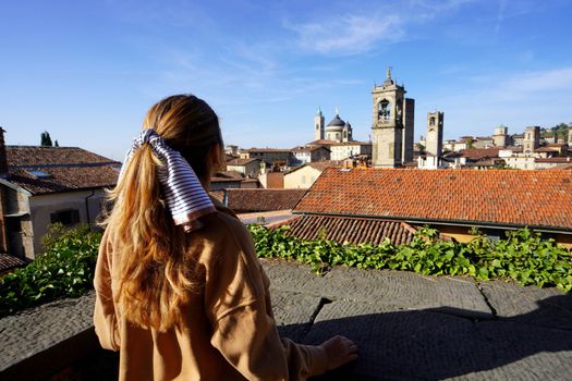 Rear view of girl looking the cityscape of Bergamo, Lombardy, Italy