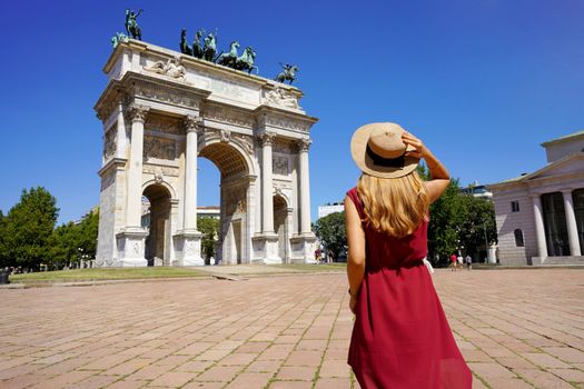 Tourism in Milan, Italy. Rear view of tourist girl holds hat in Sempione Square, Milan, Italy.