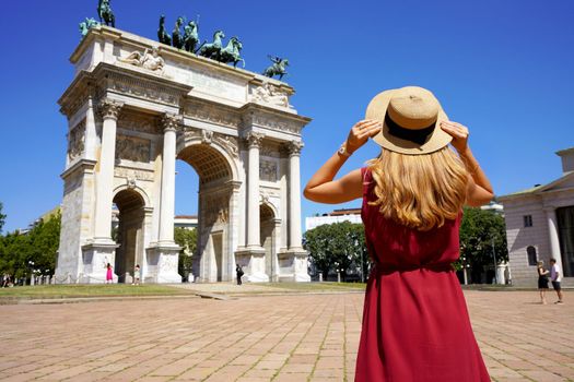 Holidays in Italy. Low angle of tourist girl looking at Triumphal Arch of the Peace in Milan, Italy.
