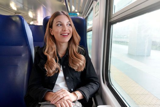 Portrait of young satisfied woman traveling with public transport sitting relaxed thoughtless