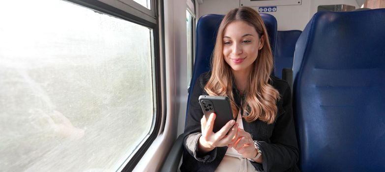 Train female passenger using mobile phone during travel commute. Panoramic banner of people lifestyle commuting on autumn.