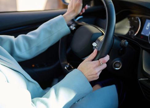 Close-up female driver's hands on steering wheel in modern automobile. Woman driving car. Car insurance, Safety driving