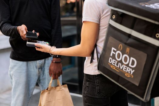 Client making contactless mobile payment for food delivery closeup
