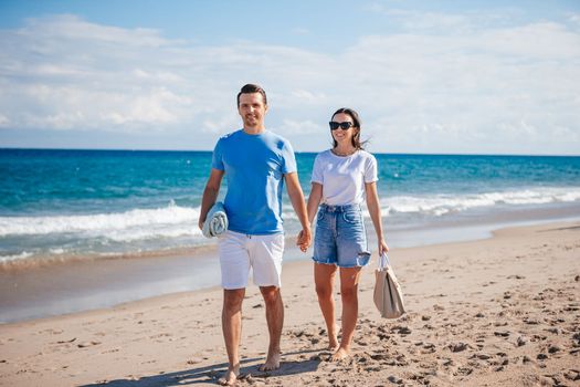 Young couple holding hands walking on the beach vacation