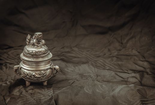 engraved decorate on Small silver ancient incense burner on dark background. 