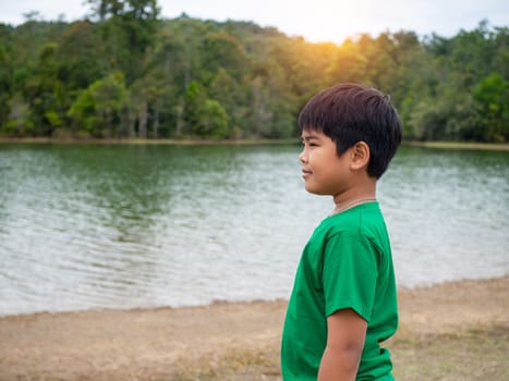 A boy stands by the reservoir in the evening. It shows looking at the goals in life.