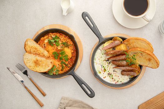 Two pan dishes with sausages and eggs