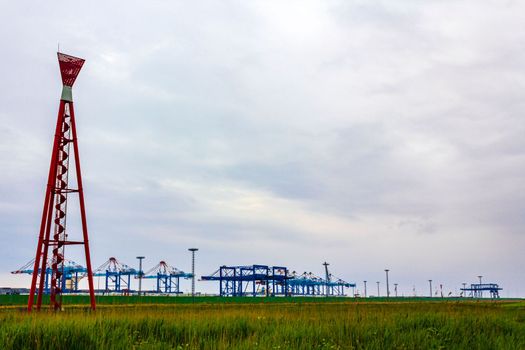 Industrial area cranes container dyke seascape panorama in Bremerhaven Germany.