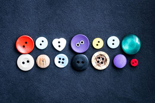 Sewing buttons lying on dark cloth