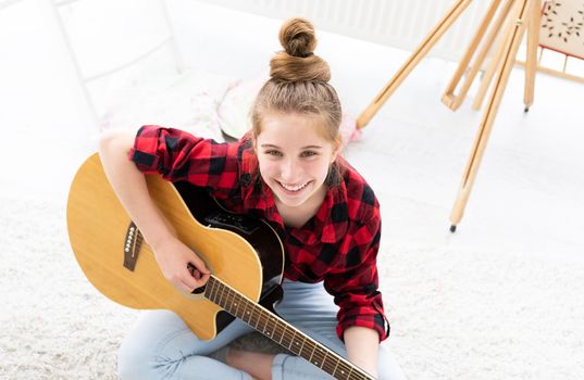 Smiling girl guitarist with musical instrument