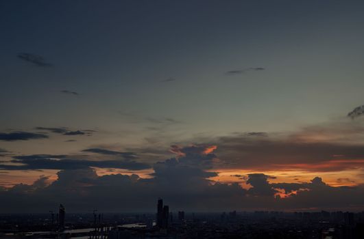 Aerial view of Gorgeous of sunset on the orange and blue sky over large metropolitan city in Bangkok.