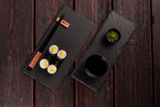 Maki sushi roll with avocado with chopsticks top view. Sushi menu. Japanese food.
