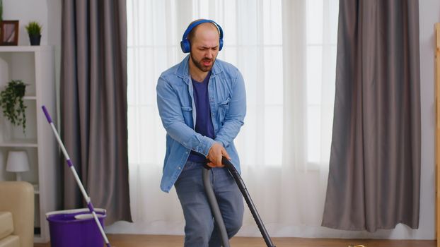 Man with headphones during housekeeping