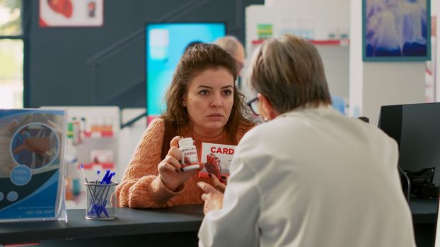 Female client showing cardiology pills to specialist