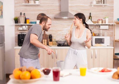 Cheerful couple dancing in kitchen