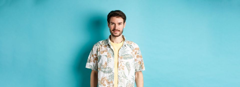 Happy handsome guy smiling, wearing hawaiian shirt on vacation. Concept of summer holiday