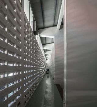 The sunlight shines through light channels wall of old gymnasium. Concrete walls have holes for sunlight to penetrate through the holes from the outside.