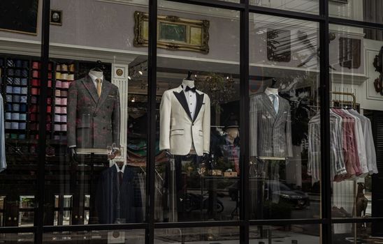 Luxury shop window with Stylish men's suits on mannequins. Men's elegant clothes.
