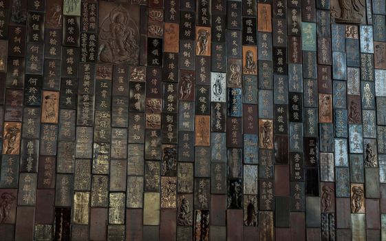 Chinese lettering teachings and Carved buddha images into a slab of colored tiles on temple wall of Fo Guang San Temple. 