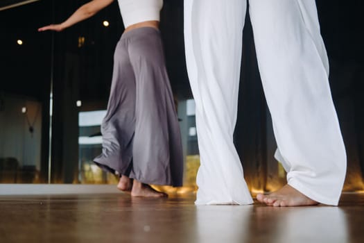 Close-up of dancing legs of women in sportswear doing dance yoga in the gym