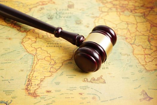 Bangkok, Thailand - December 15, 2021 Judges gavel on ancient vintage world map, international law concept.