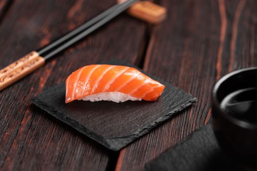 Japanese sushi food. Sushi nigiri with salmon close-up on stone natural background with wooden table