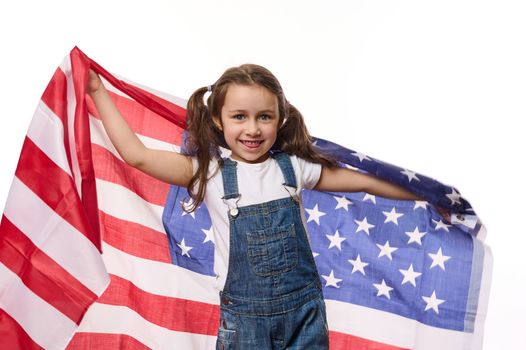 Adorable American child girl carries USA flag, celebrates Independence day on July 4. Citizenships. Immigration concept