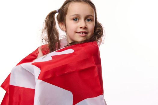 Little Canadian citizen, lovely baby girl wrapping flag of Canada, celebrates Independence Day, Dominion Day, 1st July.