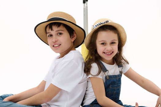 Lovely kids, brother and sister going for summer vacations traveling abroad , smile on camera, isolated white background