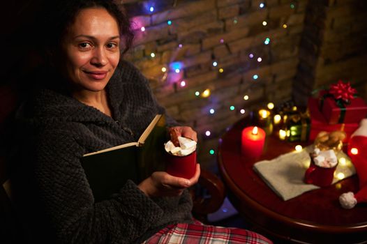 Gorgeous woman with cup of hot chocolate with marshmallows. Enjoy magic Christmas atmosphere at home