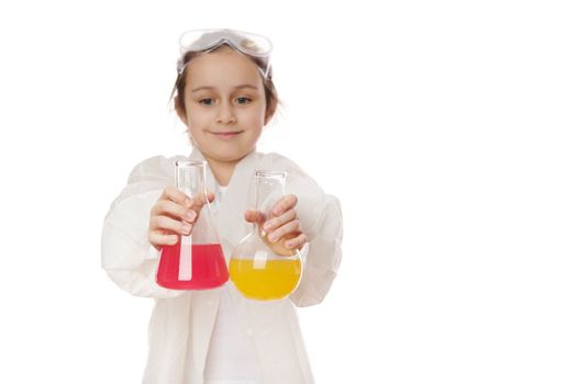 Lab flasks with chemical substances in hands of a little girl, showing the current chemical reaction at chemistry lesson