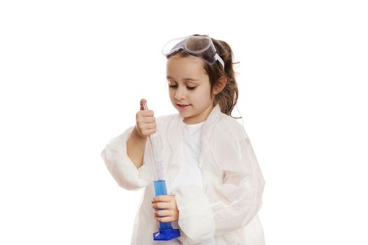 Smart little chemist dripping few reagent from laboratory pipette into a measuring glass cylinder with chemical solution