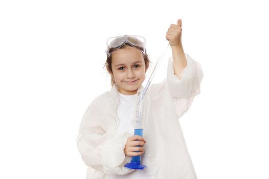 Adorable little girl drips few drops of reagent from graduated pipette into a measuring cylinder at a chemistry lesson